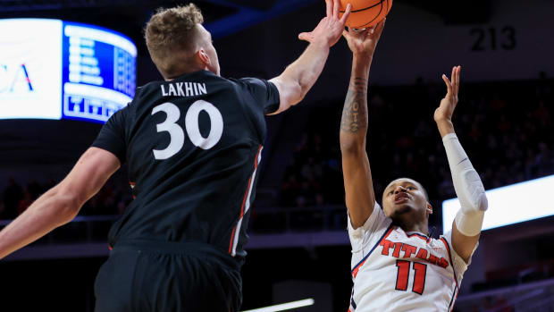 Dec 21, 2022; Cincinnati, Ohio, USA; Cincinnati Bearcats forward Viktor Lakhin (30) blocks the shot by Detroit Mercy Titans forward Gerald Liddell (11) in the second half at Fifth Third Arena. Mandatory Credit: Aaron Doster-USA TODAY Sports